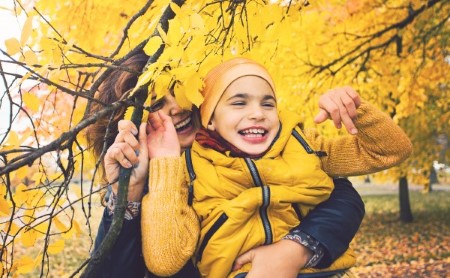 Child with cerebral palsy playing outside with his mother