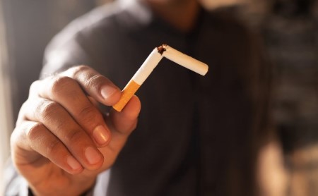 Man holding broken combustible cigarette