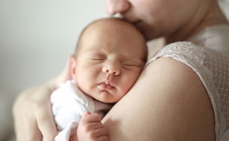 Mother cradling baby to her shoulder