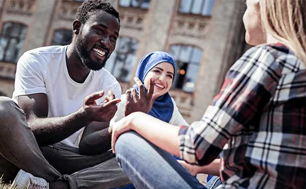 nice-man-smiling-and-pointing-at-friend-while-having-conversation.jpg