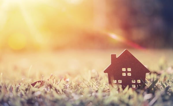 Small model home on green grass in late afternoon sunlight